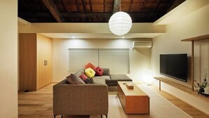 A modern living room with a sofa, a coffee table, and a television.