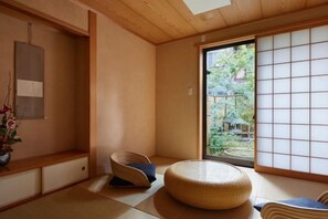 Una habitación tradicional japonesa con suelo de tatami, bajo techo de madera y puerta corredera estilo shoji.