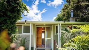 Una casa con puerta de madera, un pequeño porche y una escalera que conduce a la entrada.