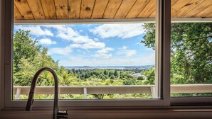 Una ventana con vistas a un paisaje verde y un cielo despejado.