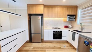 Una cocina compacta equipada con refrigerador, horno, microondas y lavavajillas.
