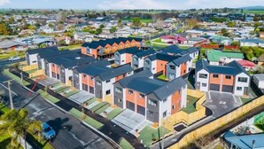 Zona residencial con casas modernas, una avenida principal y un pequeño aparcamiento.