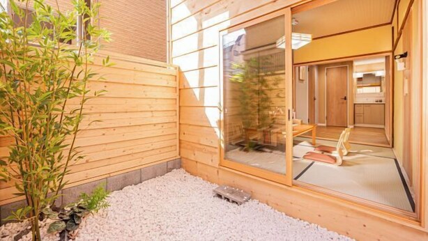 A wooden exterior with a sliding glass door leading to a room with tatami mats and a traditional Japanese interior. - skytree Family Hotel (Tokyo)