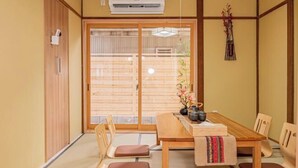 A traditional Japanese room with tatami flooring, a wooden table, and a sliding door. - skytree Family Hotel (Tokyo)