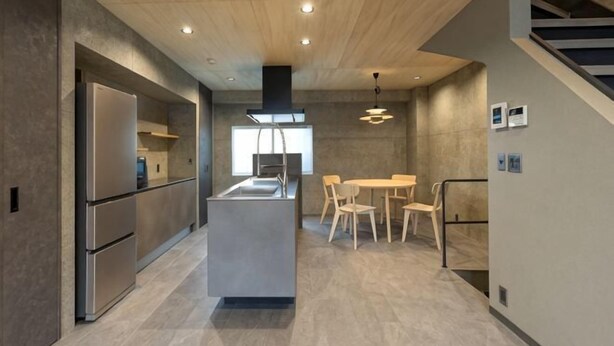 Una cocina moderna con una isla central, electrodomésticos de acero inoxidable y un comedor con sillas de madera.