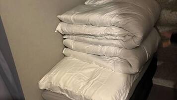 Un lecho de ropa blanca sobre una cama.