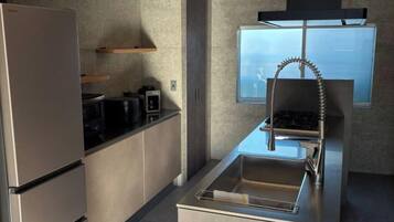 A modern kitchen with a stainless steel refrigerator, a built-in oven, and a gas stove.