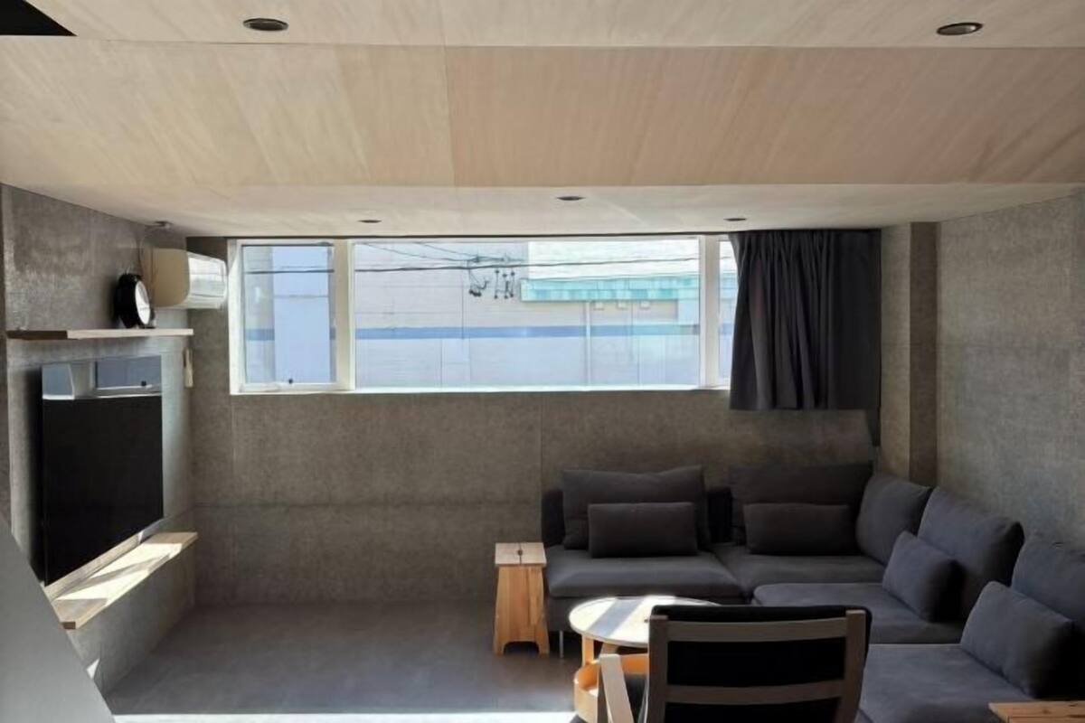 A modern living room with a sofa, a small table, and a TV.