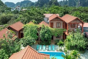 A resort with multiple buildings, a swimming pool, and lush greenery. - Trang An Family Homestay Ninh Binh (Hoa Lu District)