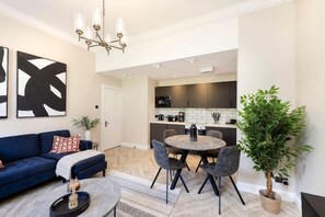 Un salon moderne comprenant un canapé, une table basse et un coin repas avec des chaises et une table.
