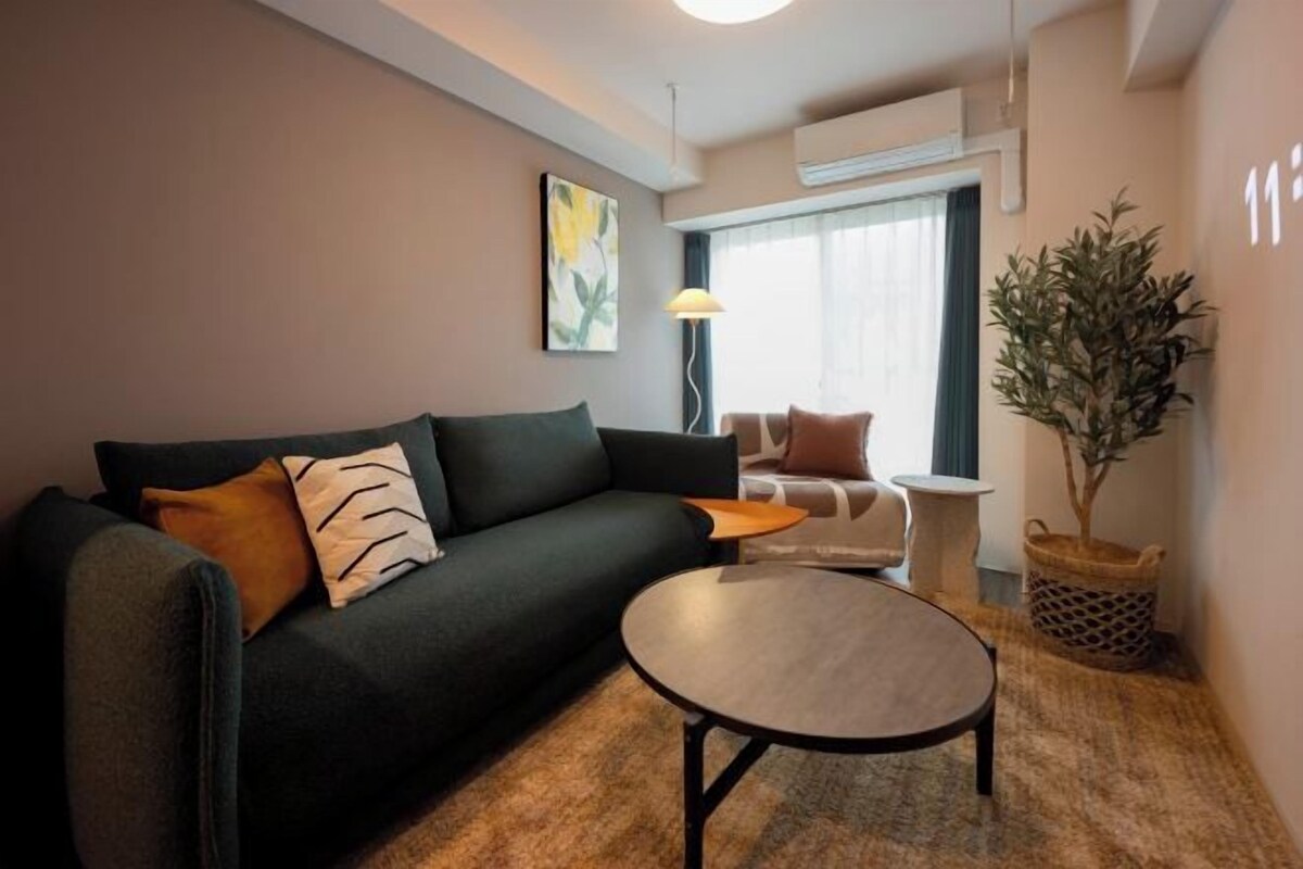A modern living room with a sofa, a coffee table, and a potted plant.