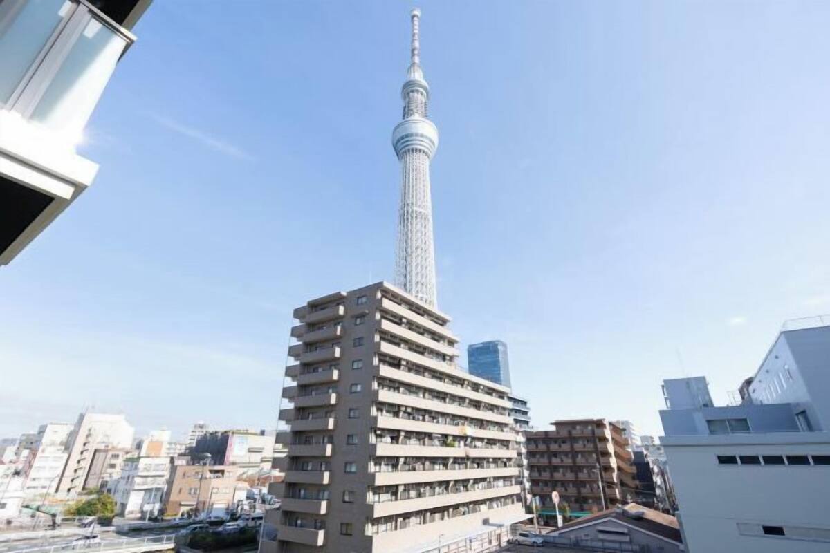 Un edificio de gran altura con una torre destacada, rodeado de otros edificios residenciales.