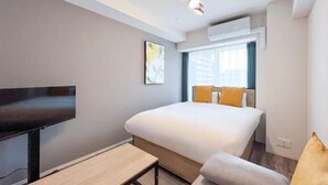 A modern hotel room with a large bed, a flat-screen TV, a small table, and a window with curtains. - LAFESTA Higashi Komagata　 (Tokyo)