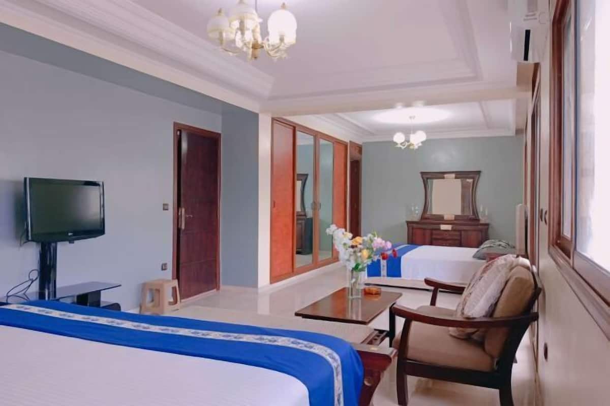 A hotel room with a bed, a TV, a desk, and a chair.