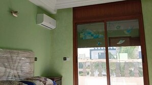 A room with green walls, a wooden door with glass panels, and an air conditioning unit mounted on the wall. - Morocco Casablanca Polar Bear Airport Homestay (Nouaceur)