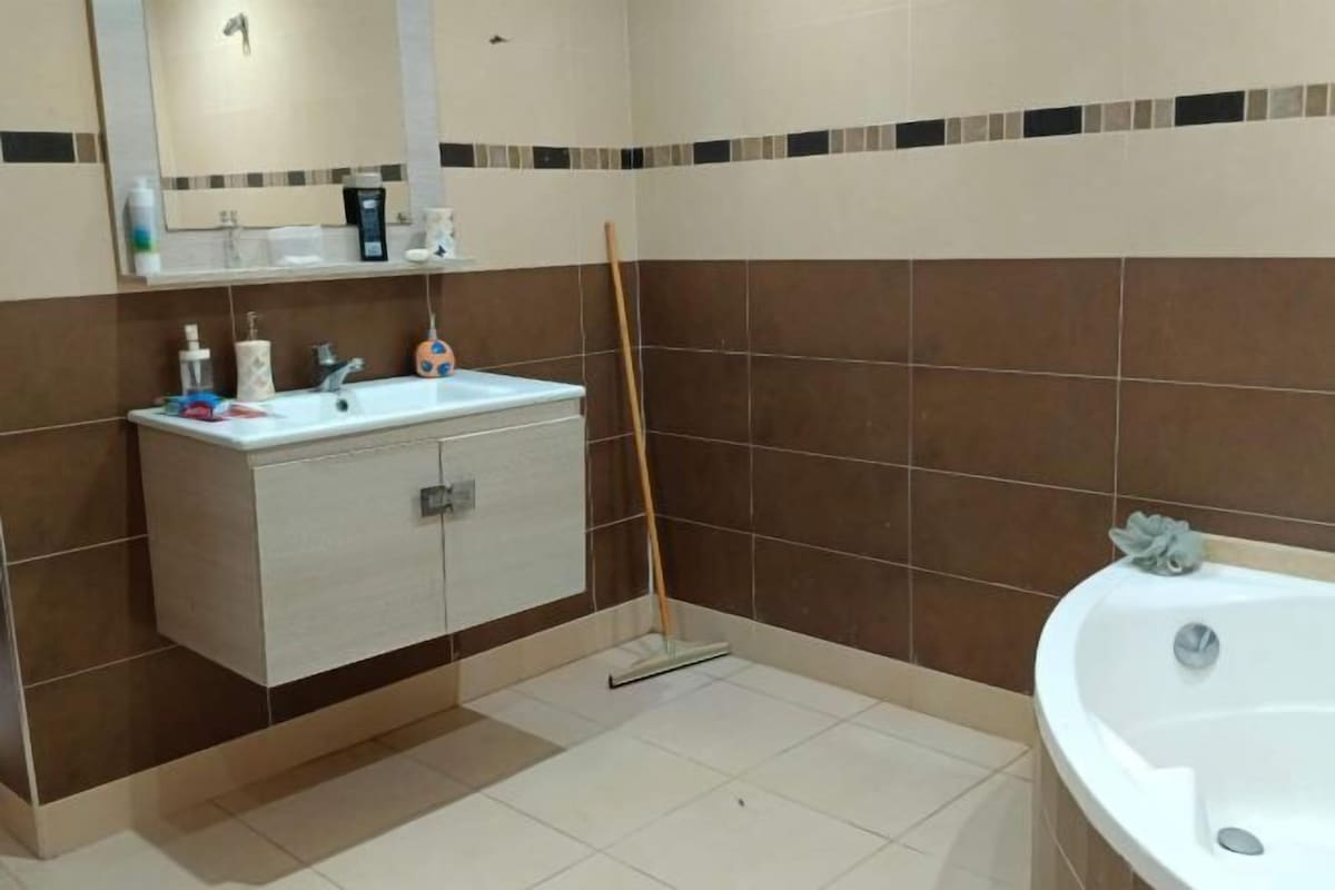 A bathroom with a white sink, mirror, and bathtub.
