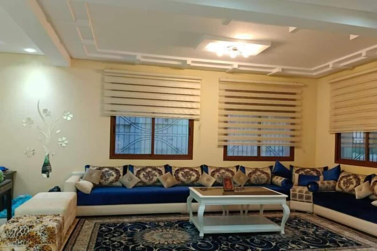 A living room with a sofa set, a coffee table, and patterned rugs.