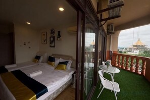 A hotel room with a balcony, a bed, a small table, and a chair. - Highfloor Riverbank Suites level 12 (Kuching)