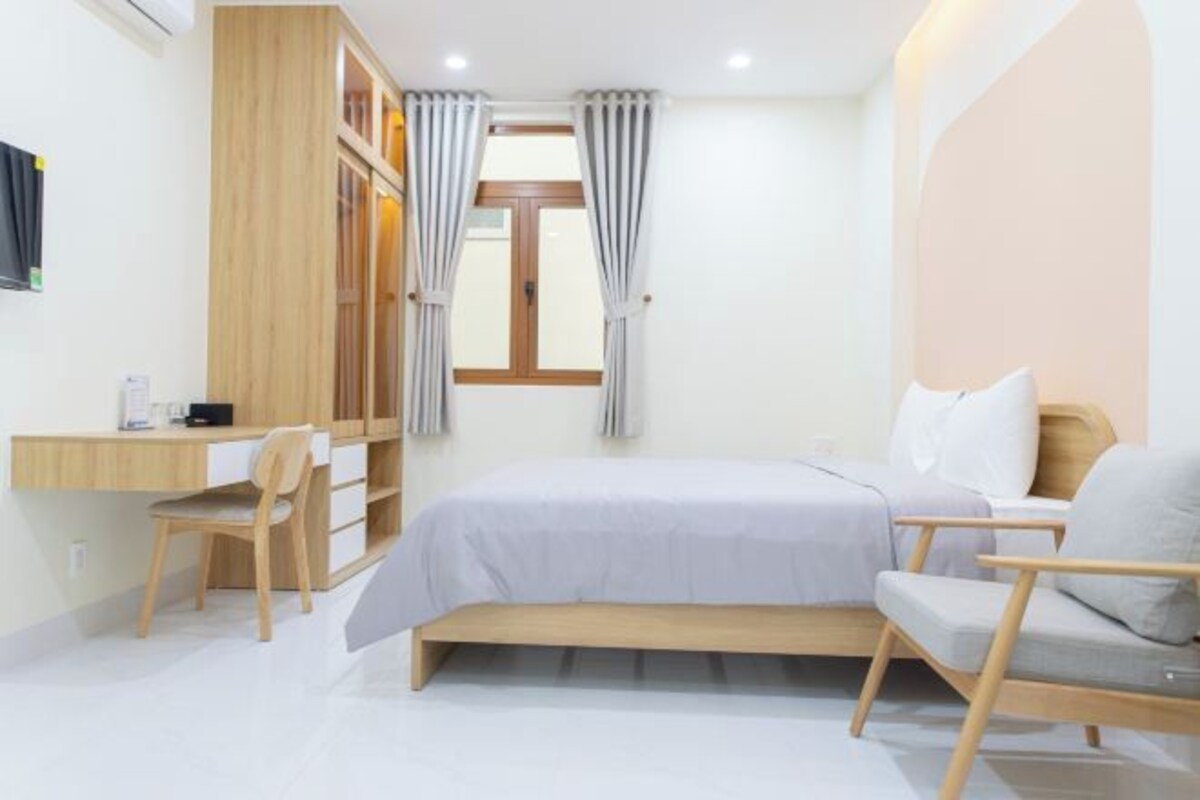 Une chambre à coucher comprenant un lit, un bureau, une chaise et une armoire.