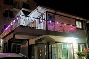 A two-story building with a balcony adorned with string lights. - Ha-Wahyeon HOUSE: Great location, views and vibe! (Geoje-si)