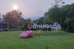 A grassy area with a sign featuring a heart and a flower.