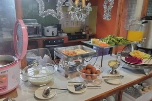 A buffet table with various food items and kitchen appliances in the background. - Korp View House (Wang Nam Khiao)