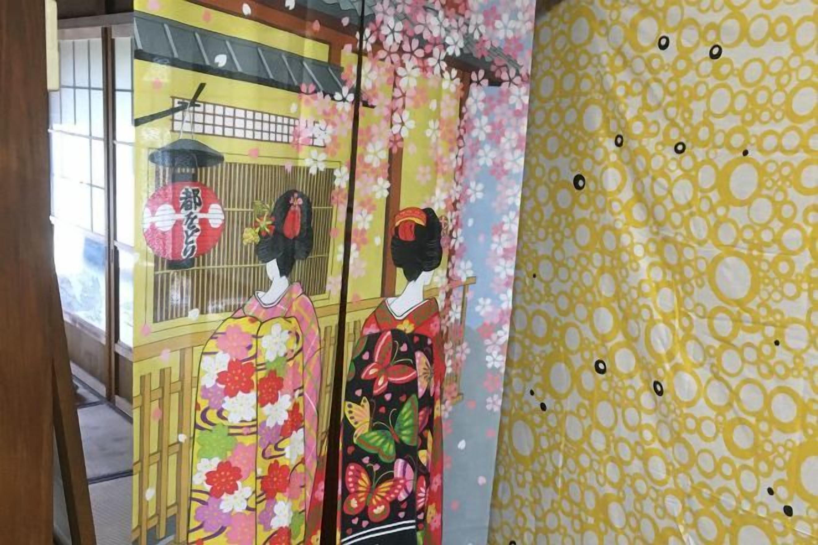 Una habitación tradicional japonesa con suelo de tatami, un mamparo shoji y decoración temática de cerezo.