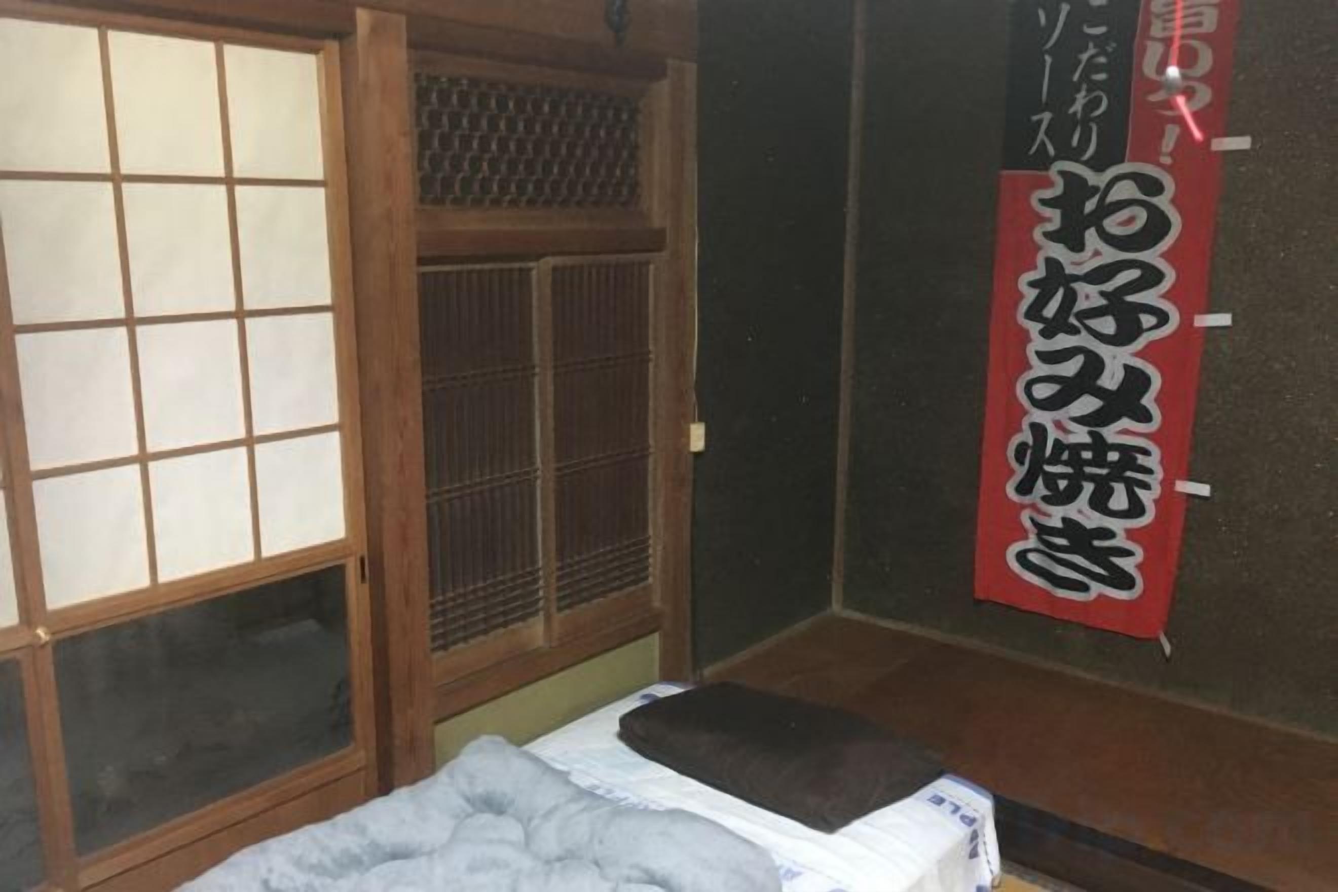 Um quarto japonês tradicional com tatames, uma porta de tela shoji e uma cama futon.