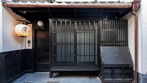 A traditional Japanese entrance with a sliding gate, a lantern, and a small step leading up to the door. - KIRAKU KYOTO RINPA (Kyoto)
