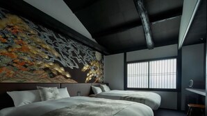 A modern bedroom with a large bed, a headboard with a decorative wall piece, and a window with blinds. - KIRAKU KYOTO RINPA (Kyoto)