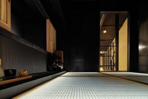 A traditional Japanese room with tatami flooring, sliding doors, and a low wooden table with a tea set. - KIRAKU KYOTO RINPA (Kyoto)