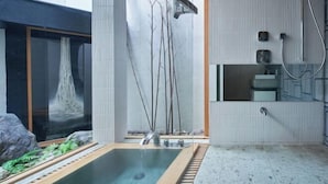 A modern bathroom with a rectangular bathtub, a glass shower enclosure, and a small sink area. - KIRAKU KYOTO RINPA (Kyoto)