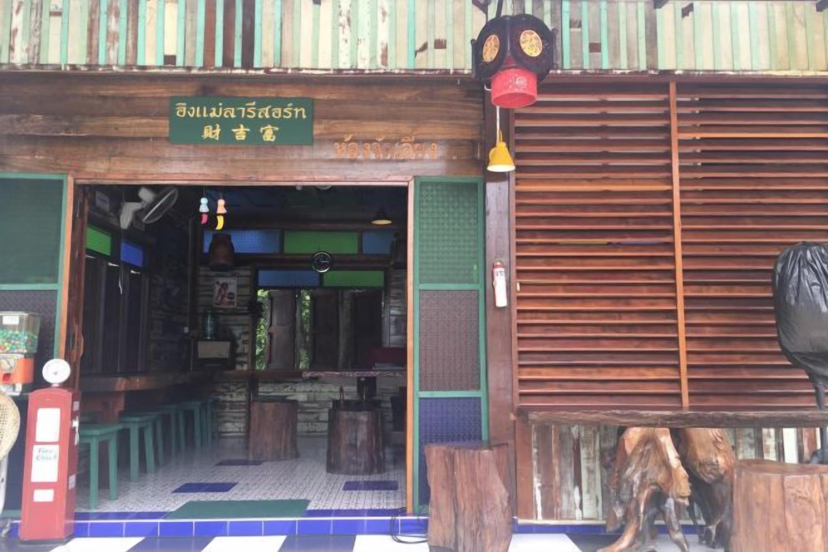 A traditional Thai restaurant with a wooden exterior and a sign in Thai.