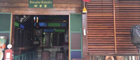 A traditional Thai restaurant with a wooden exterior and a sign in Thai.