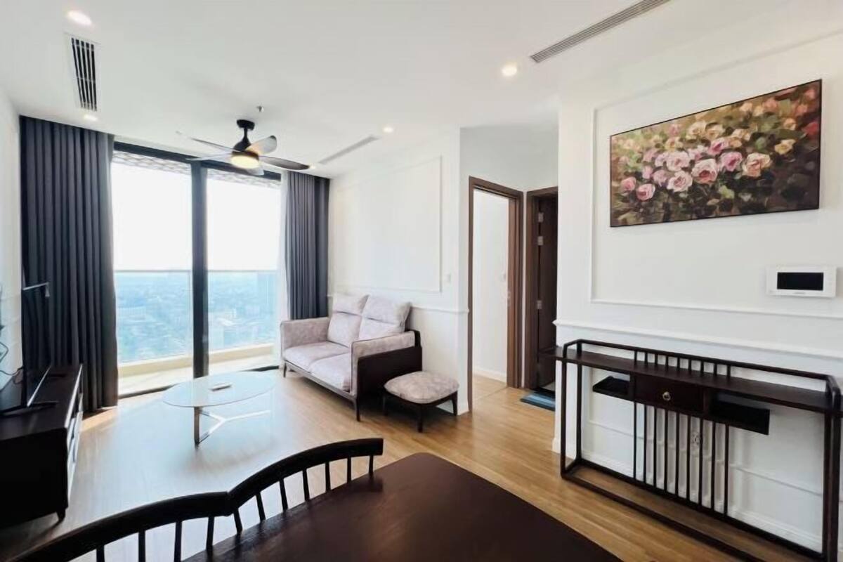 Uma sala de estar moderna com um sofá, uma mesa de jantar e um quadro na parede.