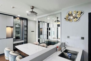 A modern kitchen with a marble countertop, built-in appliances, and a large mirror. - Vinhomes Skylake Residence Hanoi City - Mango Housing (Hanoi)