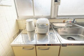 Una cucina con un piano di lavoro in acciaio inox, una macchina da caffè e un lavandino.