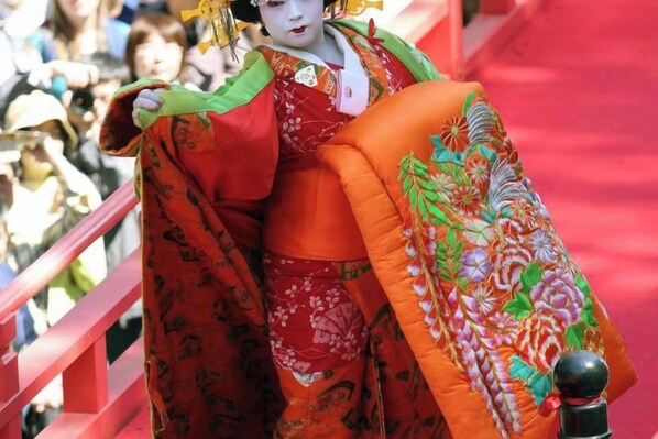A person in traditional attire holding a colorful fabric. - Injie Hotel Shimonoseki (Shimonoseki)