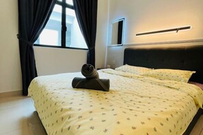 A hotel room with a bed, a window with curtains, a bedside table, and a wall-mounted light fixture. - Desaru Utama A14 by UcomeHomestay (Bandar Penawar)