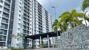 A modern high-rise building with a stone entrance and a sign reading "Pangsapuri Desaru Utama." - Desaru Utama A14 by UcomeHomestay (Bandar Penawar)