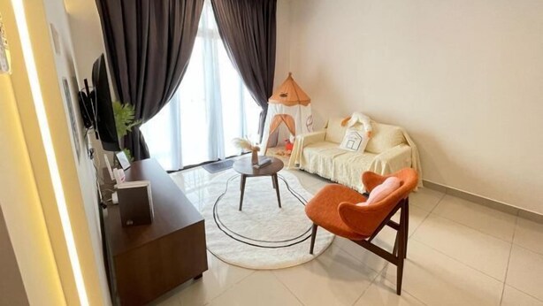 A modern living room with a sofa, a round coffee table, a chair, and a TV. - Desaru Utama A14 by UcomeHomestay (Bandar Penawar)