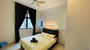 Quarto com cama, ventilador de teto, janela com cortinas e mesa de cabeceira.