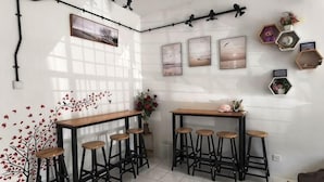 Een kamer met een bar, krukken, een betegelde vloer en decoraties aan de muur.
