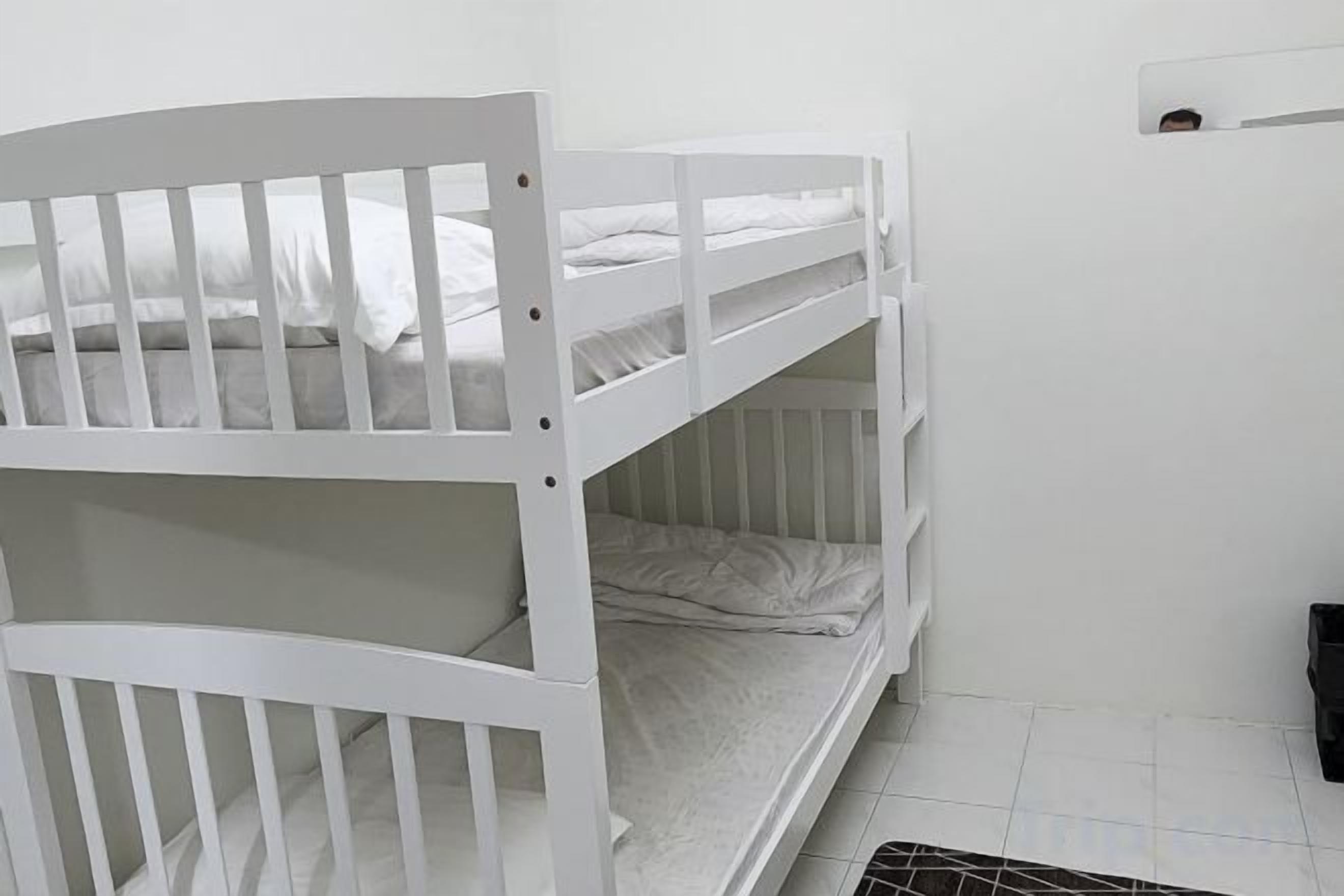 A white bunk bed with a lower bunk and a headboard.