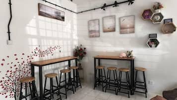 Een hoekappartement met een bar, barkrukken en decoratieve wandpanelen.