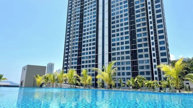 A high-rise hotel with a swimming pool in front. - JQ Unity Homestay Seaview 6pax (Kota Kinabalu)