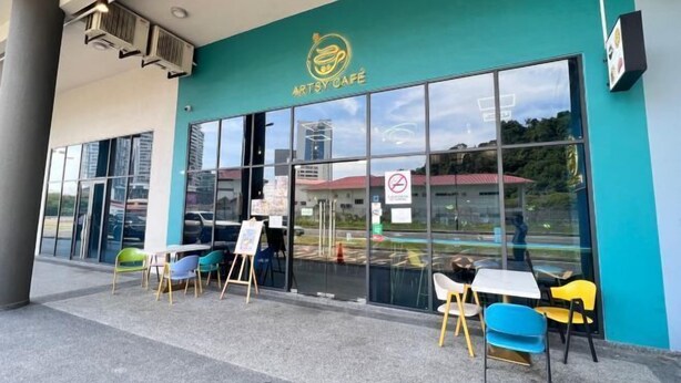 The exterior of Artsy Café with large windows, outdoor seating, and a teal-colored wall. - JQ Unity Homestay Seaview 6pax (Kota Kinabalu)