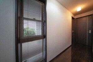 A hallway with a door, a window with blinds, and a light fixture. - 10 Min Walk to Ikebukuro Station 4BR Private House 3 Min to Kanamecho Sleeps 8 (Tokyo)