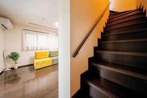 A modern living room with a wooden staircase. - 10 Min Walk to Ikebukuro Station 4BR Private House 3 Min to Kanamecho Sleeps 8 (Tokyo)
