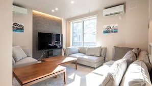 A modern living room with a flat-screen TV, two sofas, a coffee table, and a fireplace. - Ciel MinamiAzabu (Tokyo)